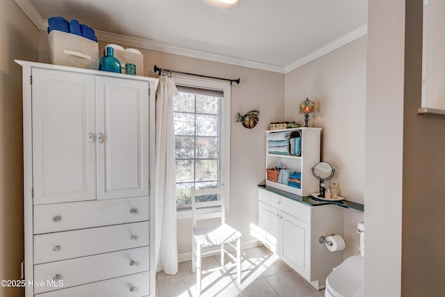 bathroom featuring tile patterned flooring, crown molding, and toilet