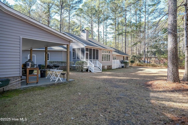 view of side of property with a patio and a sunroom