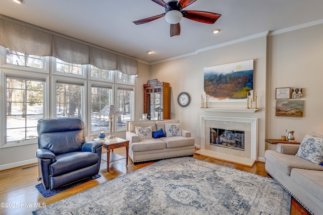 living room featuring ceiling fan, ornamental molding, and light hardwood / wood-style floors
