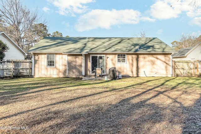 back of property with a lawn and a patio