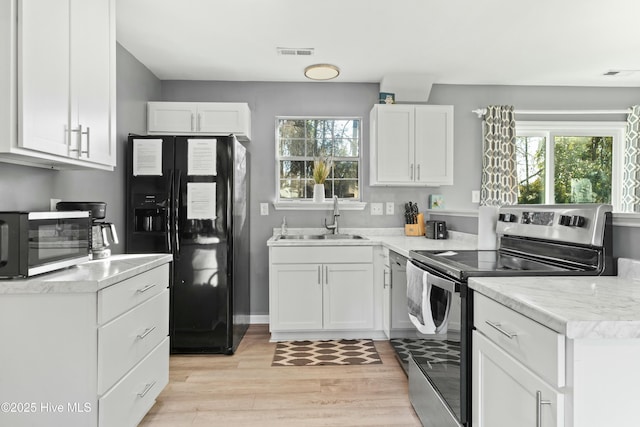 kitchen featuring sink, light wood-type flooring, white cabinets, and appliances with stainless steel finishes