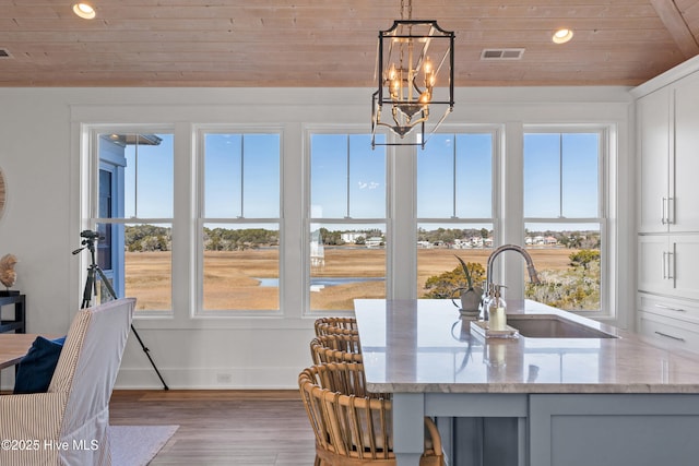 sunroom / solarium with lofted ceiling, sink, an inviting chandelier, and wood ceiling