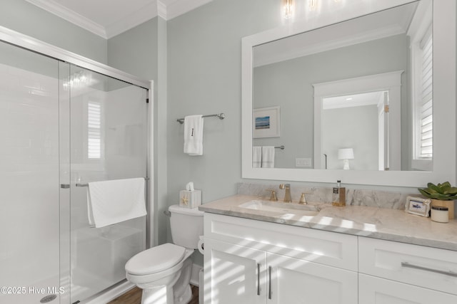 bathroom with ornamental molding, vanity, toilet, and an enclosed shower