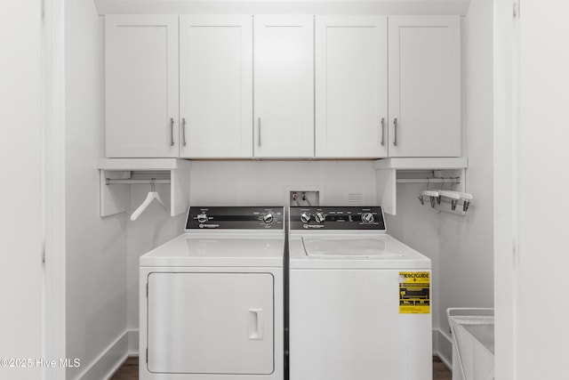 clothes washing area featuring cabinets and washing machine and dryer