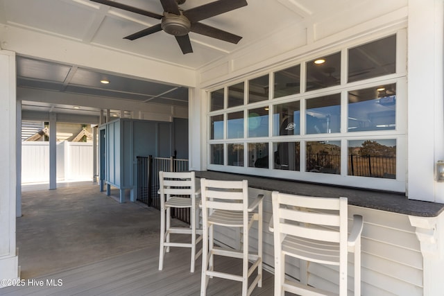 wooden terrace with an outdoor bar and ceiling fan