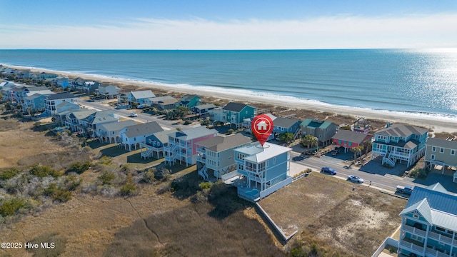 drone / aerial view featuring a water view and a view of the beach