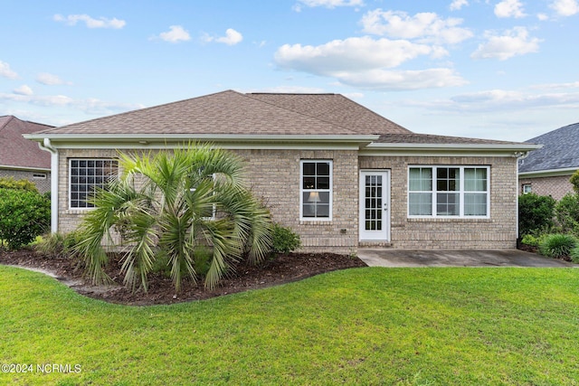 rear view of house featuring a lawn