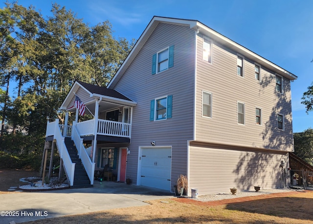 back of house with a garage and a porch