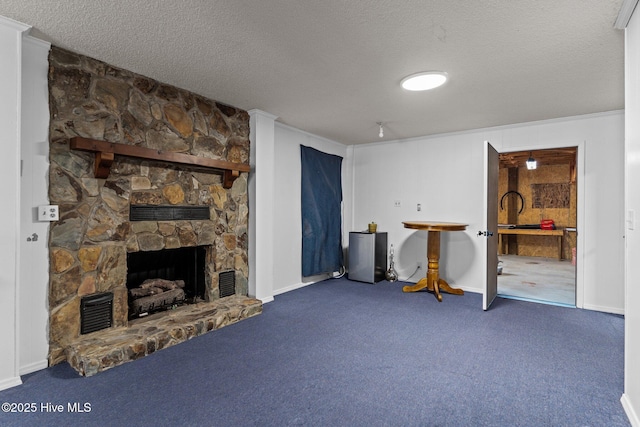 living room featuring a stone fireplace, ornamental molding, a textured ceiling, and carpet flooring