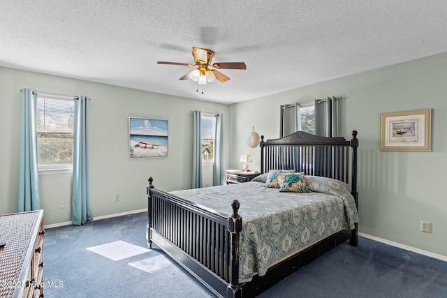 carpeted bedroom with ceiling fan, multiple windows, and a textured ceiling