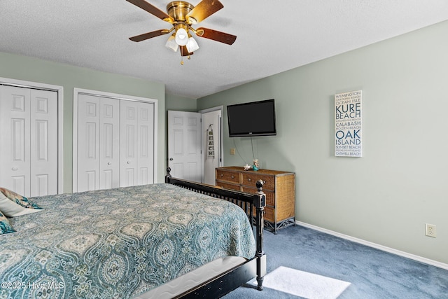 bedroom with multiple closets, a textured ceiling, carpet floors, and ceiling fan