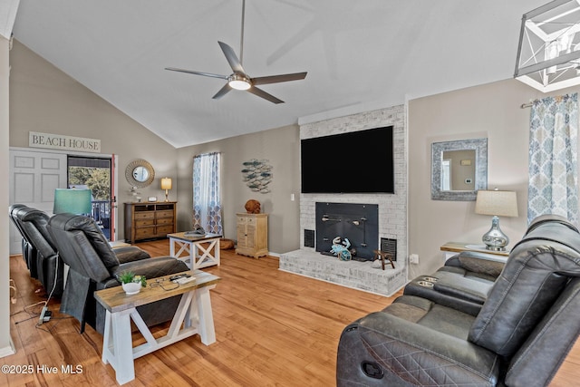 living room featuring a fireplace, hardwood / wood-style flooring, vaulted ceiling, and ceiling fan