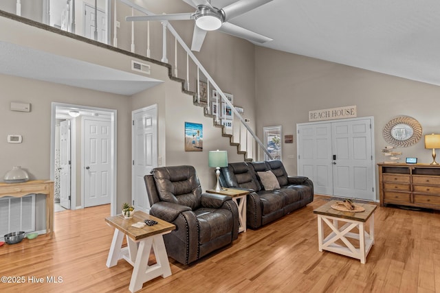 living room with hardwood / wood-style flooring and a towering ceiling