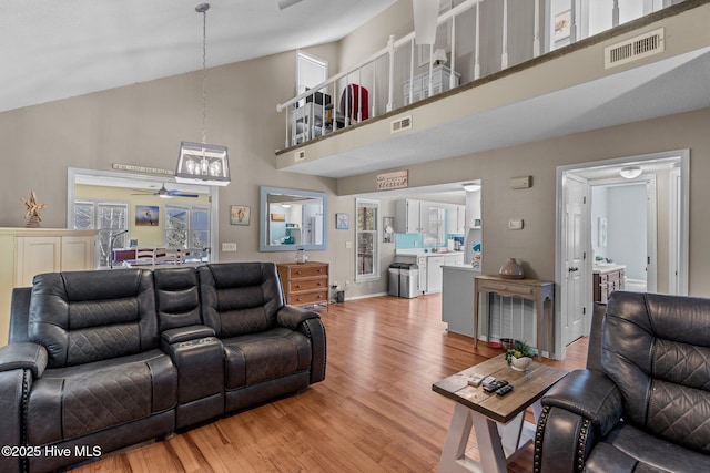 living room with high vaulted ceiling, light hardwood / wood-style floors, and ceiling fan