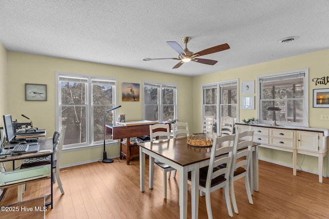 dining room featuring ceiling fan, a textured ceiling, and light wood-type flooring