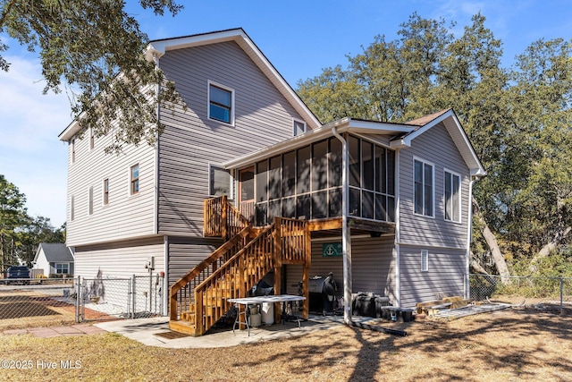 rear view of house featuring a sunroom