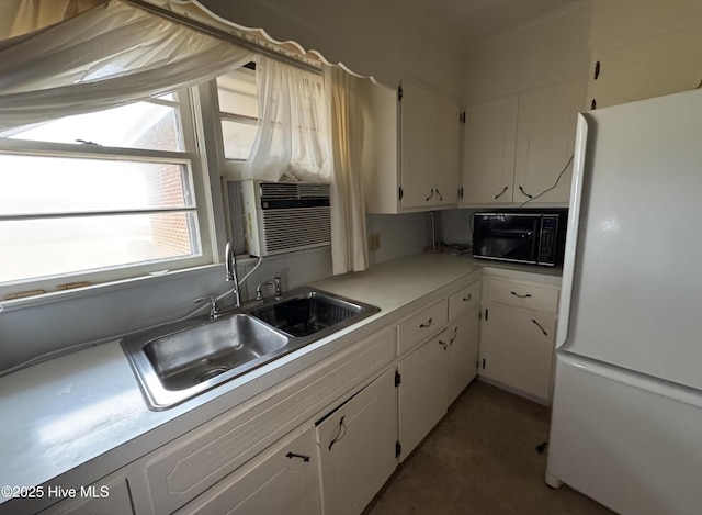 kitchen with sink, white cabinets, cooling unit, and white fridge