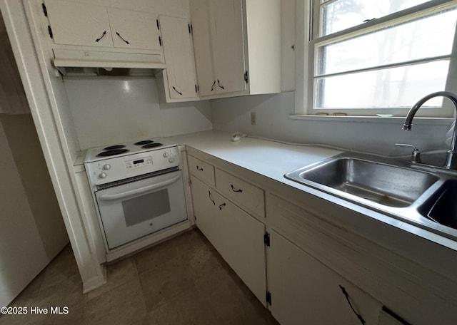 kitchen featuring dark tile patterned flooring, white cabinetry, white electric stove, sink, and wall oven