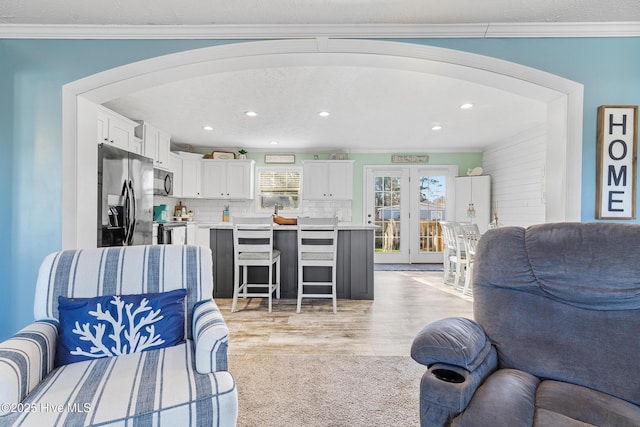 living room with ornamental molding and light hardwood / wood-style floors