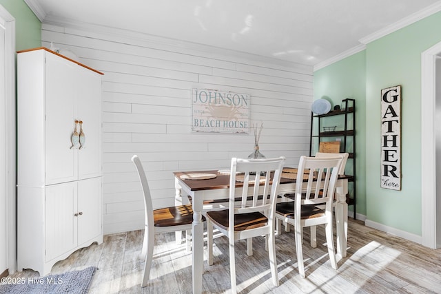 dining space with light hardwood / wood-style flooring and ornamental molding