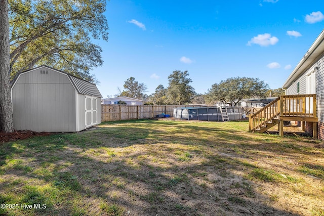 view of yard featuring a fenced in pool and a storage unit