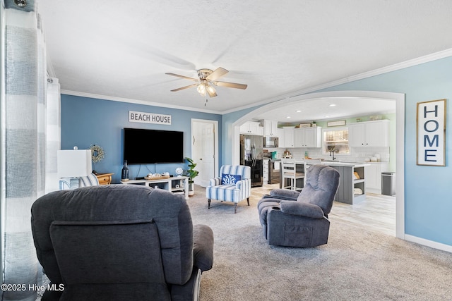 living room featuring ceiling fan, ornamental molding, and light carpet