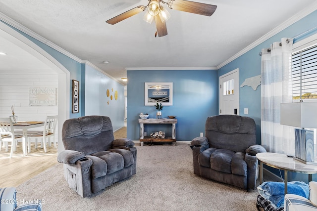 living room with ornamental molding and ceiling fan