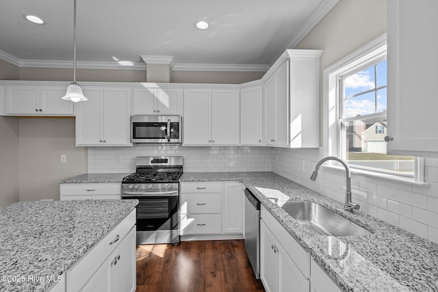 kitchen featuring sink, pendant lighting, backsplash, stainless steel appliances, and light stone counters