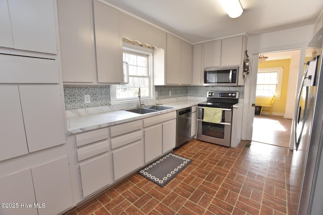 kitchen featuring sink, plenty of natural light, decorative backsplash, and stainless steel appliances