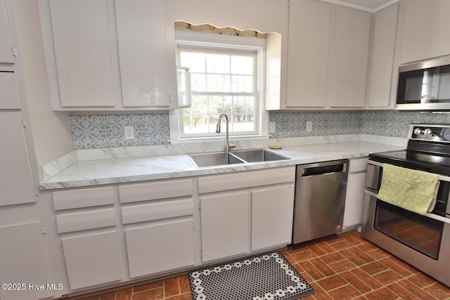 kitchen featuring sink, stainless steel appliances, white cabinets, and backsplash