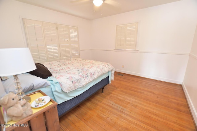 bedroom featuring ceiling fan, light hardwood / wood-style flooring, and a closet