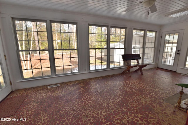 unfurnished sunroom with ceiling fan