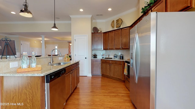 kitchen with light stone countertops, decorative light fixtures, stainless steel appliances, tasteful backsplash, and sink