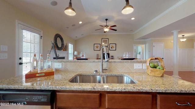 kitchen featuring ornate columns, sink, light stone countertops, black dishwasher, and lofted ceiling