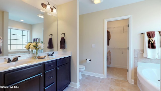 bathroom with a washtub, tile patterned floors, toilet, and vanity