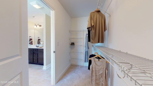 spacious closet featuring sink and light carpet