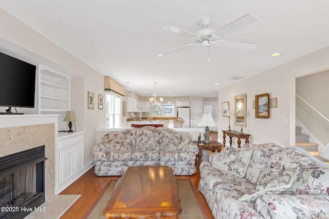 living room featuring ceiling fan, light hardwood / wood-style floors, and built in features