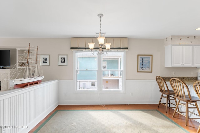 dining space featuring a notable chandelier and light wood-type flooring