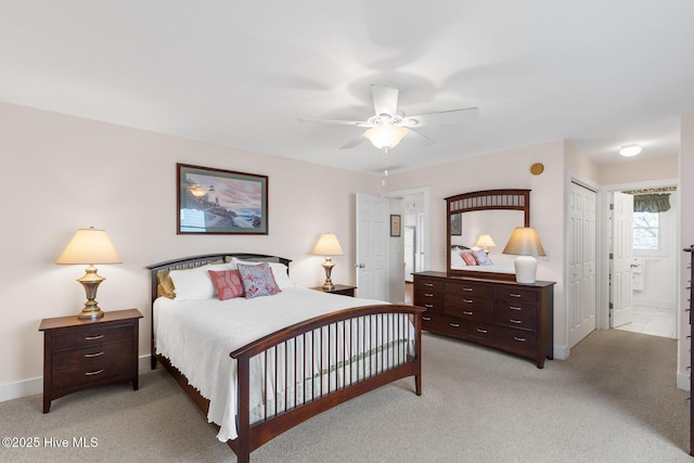 bedroom featuring ceiling fan, ensuite bathroom, and light carpet