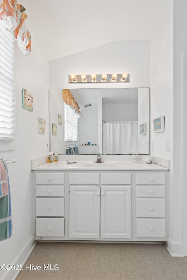 bathroom with vanity, a shower with curtain, and vaulted ceiling