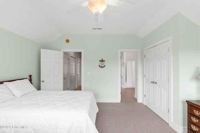 carpeted bedroom featuring ceiling fan, vaulted ceiling, and a closet