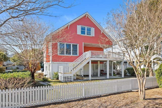 front facade featuring a wooden deck and a patio