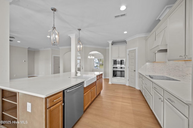 kitchen with a large island, appliances with stainless steel finishes, premium range hood, white cabinetry, and light stone counters