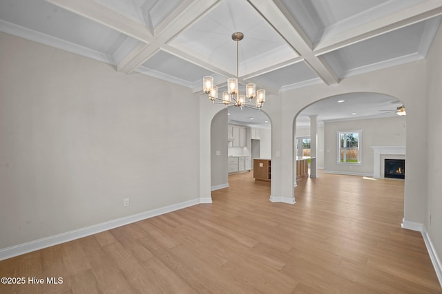 interior space with ornamental molding, coffered ceiling, beam ceiling, and light hardwood / wood-style floors