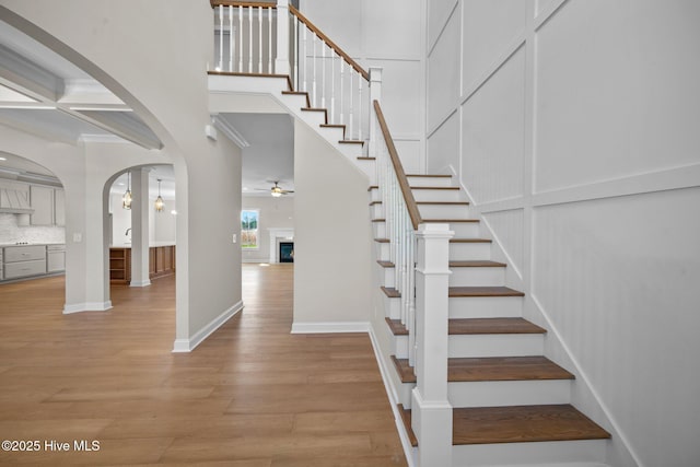 stairway with hardwood / wood-style flooring, beam ceiling, ceiling fan, and coffered ceiling