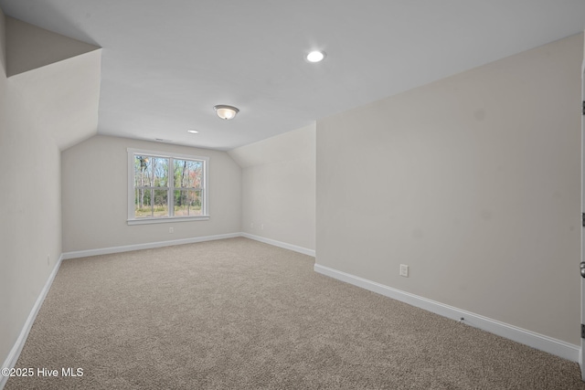 additional living space with vaulted ceiling and carpet floors