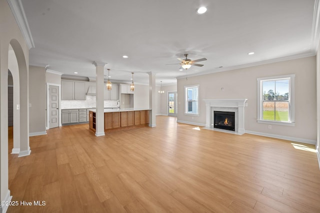 unfurnished living room with crown molding, a healthy amount of sunlight, and a premium fireplace