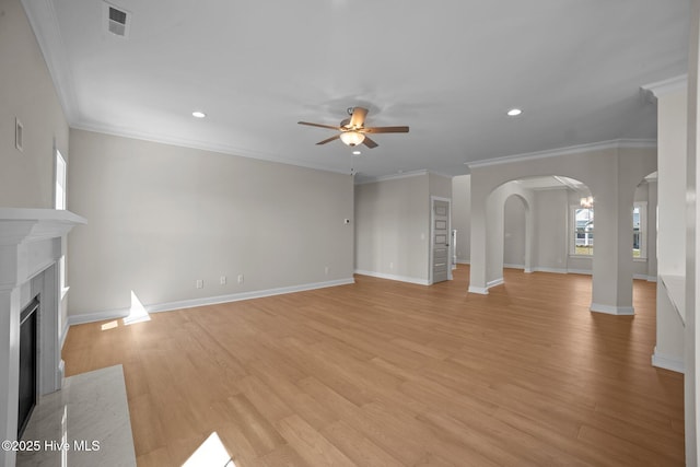 unfurnished living room with light wood-type flooring, ceiling fan, and crown molding