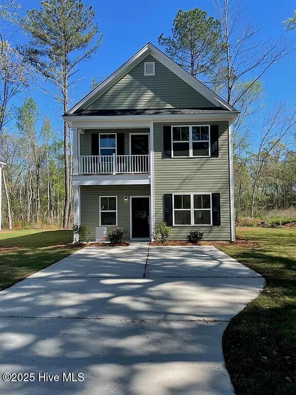 view of front of home featuring a balcony and a front yard