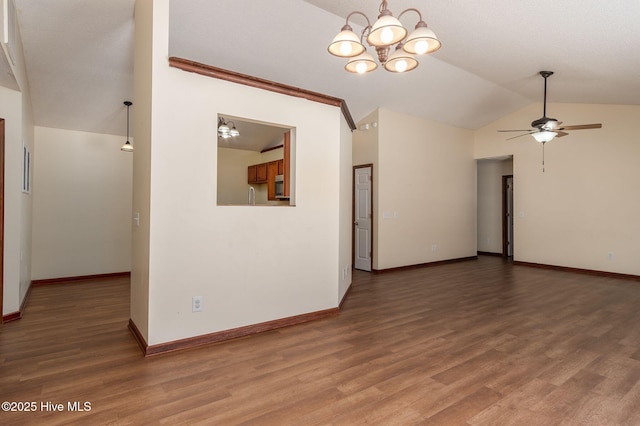 empty room featuring ceiling fan with notable chandelier, lofted ceiling, and hardwood / wood-style floors